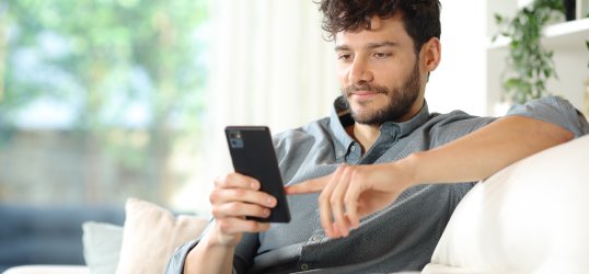 Imagen de un chico en el sofá con su teléfono